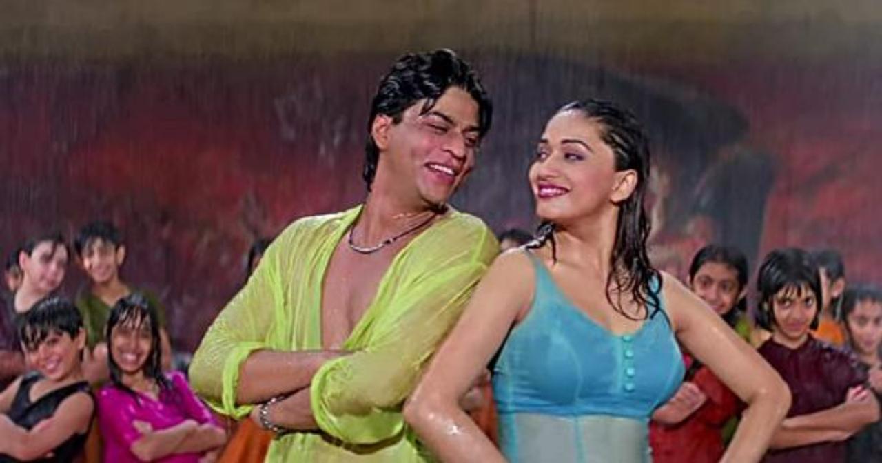 4. Dil Toh Pagal Hai
After a long day of dance rehearsals, a heavy downpour stands between Madhuri Dixit and Shah Rukh Khan’s journey of reaching home. The kids outside their studio dance in a carefree manner in the rain – and the duo soon joins them in the iconic song – ‘Koi Ladki Hai’. The rain seems to wash off their exhaustion in this number